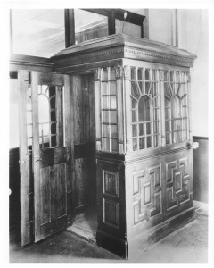 1890s-3 -
This shows one of our earliest telephone booths. It had double wall, dome roof and swing doors and was 50" to 60" square. In those days it was considered proper to have rugs, lace curtains and fancy cabinet woodwork to fittingly impress the public with the wonders of the telephone.