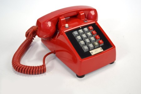 Title: Autovon telephone
Description: Autovon telephone made by ITT, red with hard wired cords.